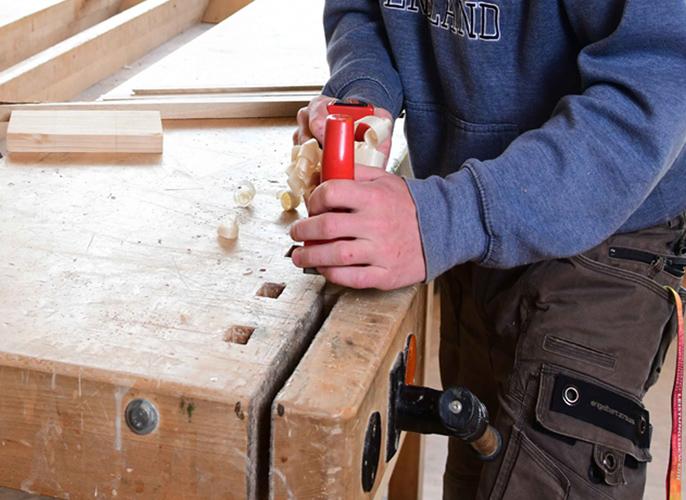 Schüler in der Tischlerei beim Hobeln